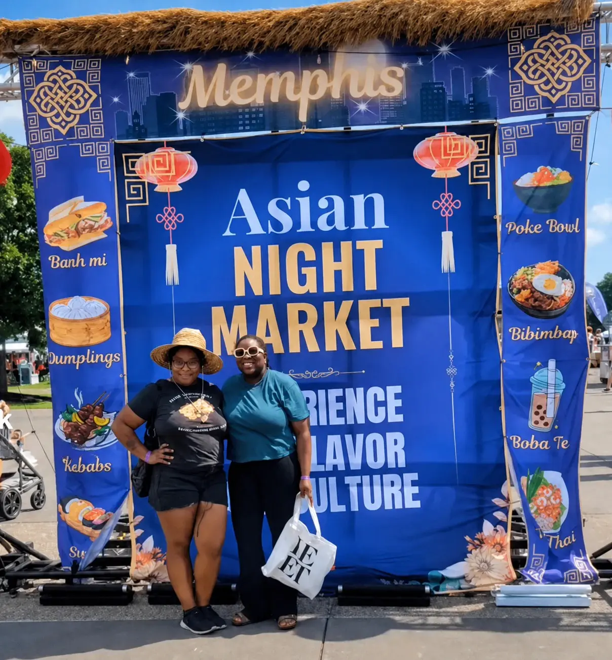Two friends smiling at the welcome gate of Asian Night Market Memphis 2025