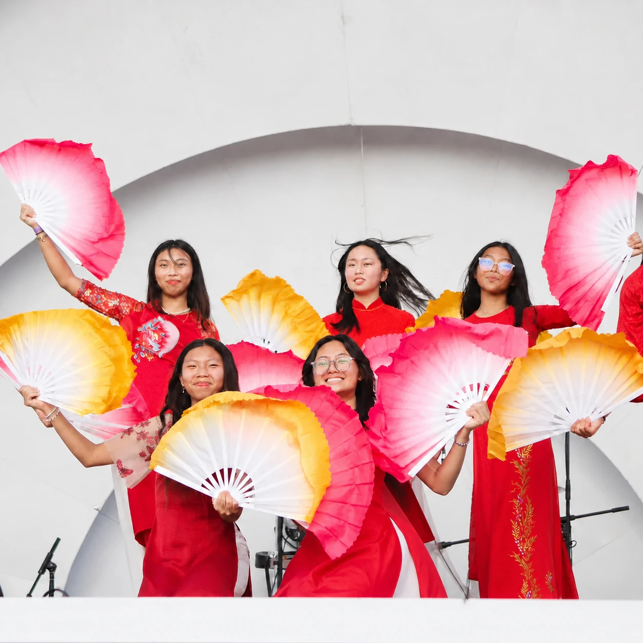 Fan dancers in red ao dai performing on stage