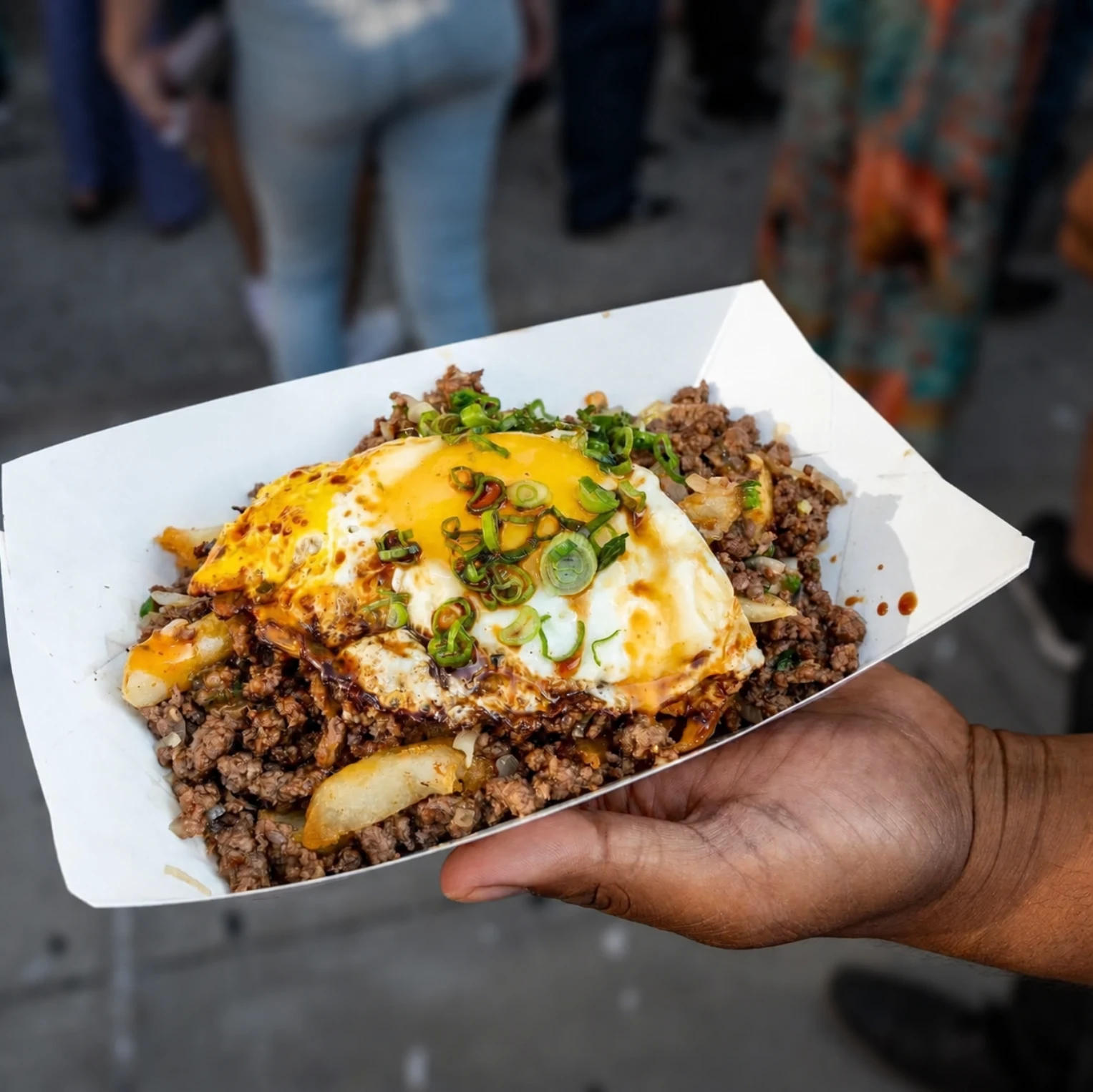 Street food rice bowl topped with a fried egg and scallions
