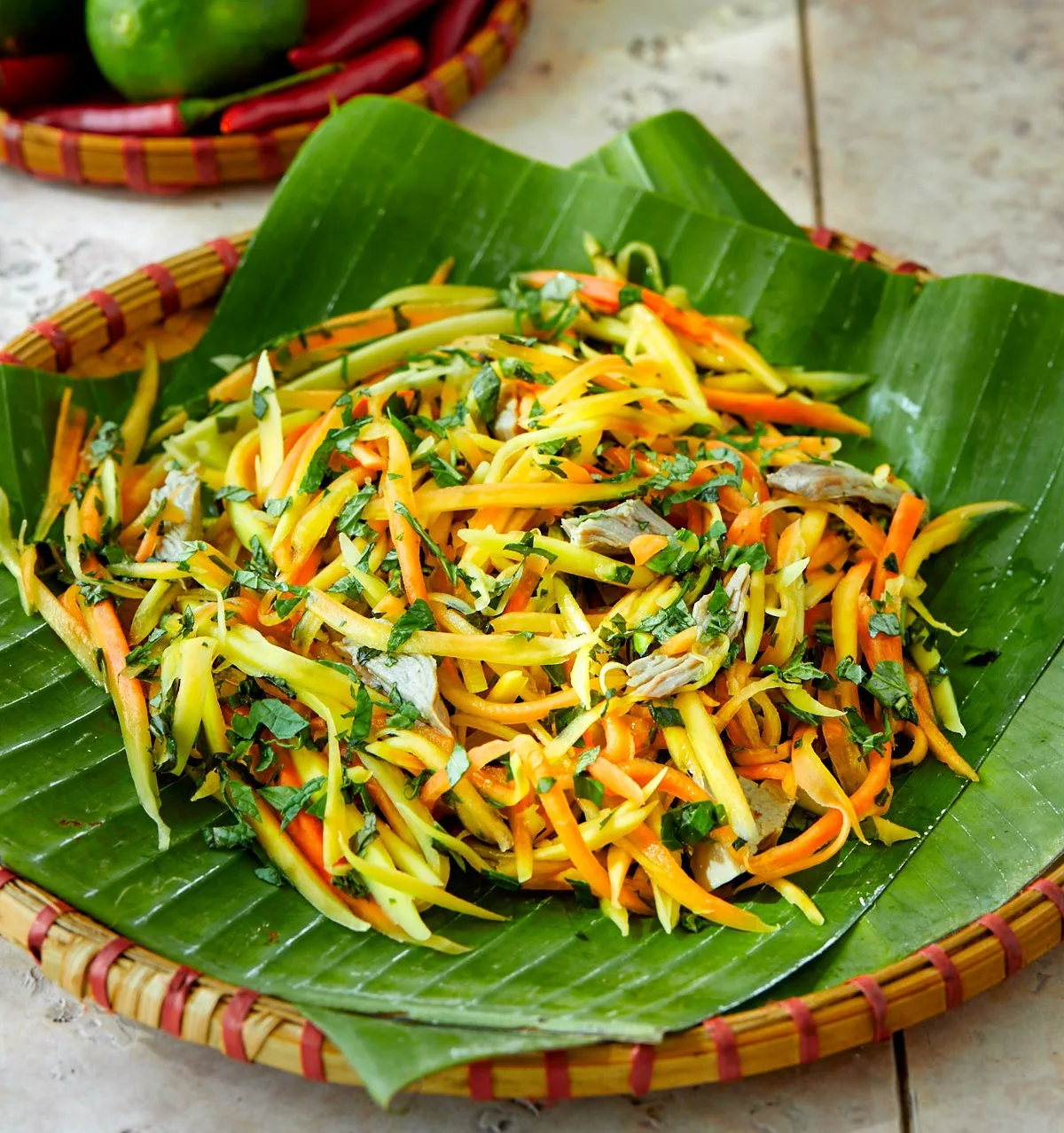 Shredded green papaya salad with carrots and herbs on a banana leaf